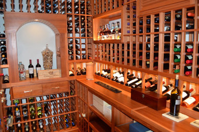 Example of a mid-sized classic medium tone wood floor wine cellar design
