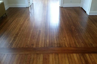 Inspiration for a mid-sized timeless open concept medium tone wood floor and brown floor living room remodel in St Louis with gray walls
