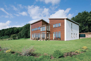 This is an example of a medium sized and brown contemporary two floor house exterior in Edinburgh with wood cladding.
