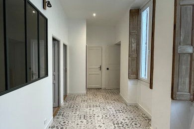 Idées déco pour un couloir moderne de taille moyenne avec un mur blanc, un sol en carrelage de céramique et un sol gris.