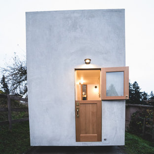 Imagen de fachada gris, contemporánea, pequeña, de una planta, con revestimiento de hormigón y tejado plano