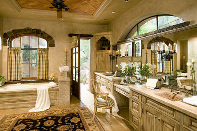 Inspiration for a large mediterranean master beige tile ceramic tile and beige floor bathroom remodel in Phoenix with an undermount sink, granite countertops, an undermount tub, beige walls, beige cabinets, raised-panel cabinets and beige countertops
