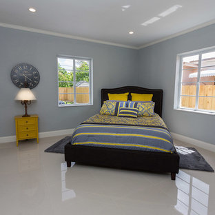 Idée de décoration pour une chambre parentale design de taille moyenne avec un mur bleu, un sol en linoléum, aucune cheminée et un sol beige.