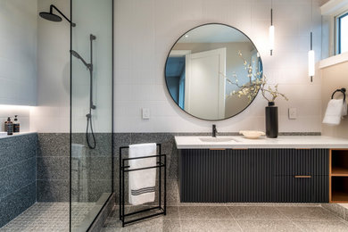 Example of a mid-sized minimalist 3/4 white tile and ceramic tile porcelain tile, gray floor and single-sink doorless shower design in Toronto with louvered cabinets, black cabinets, a one-piece toilet, white walls, an undermount sink, quartz countertops, white countertops, a niche and a floating vanity