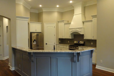 Elegant u-shaped dark wood floor eat-in kitchen photo in New Orleans with a farmhouse sink, raised-panel cabinets, white cabinets, granite countertops, gray backsplash, subway tile backsplash, stainless steel appliances and an island