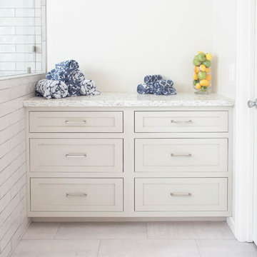 Grey/tan bathroom vanity with her and hers sinks, built-in counter with dresser