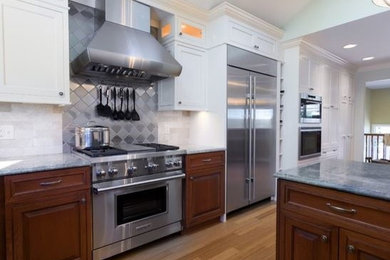 Inspiration for a huge timeless l-shaped bamboo floor and brown floor eat-in kitchen remodel in Providence with a double-bowl sink, beaded inset cabinets, beige cabinets, granite countertops, beige backsplash, marble backsplash, stainless steel appliances and two islands
