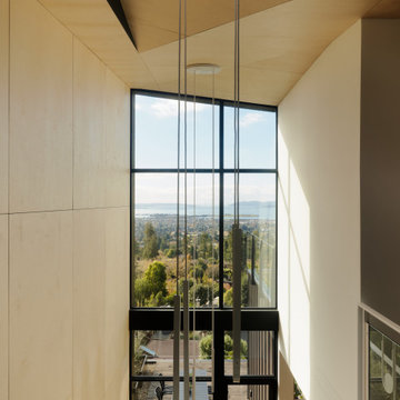 Double-height stair void with folded ceiling plane, pendant drops - Fold House