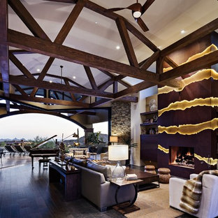 Geräumiges, Offenes Mediterranes Wohnzimmer mit Hausbar, weißer Wandfarbe, dunklem Holzboden und verstecktem TV in Phoenix