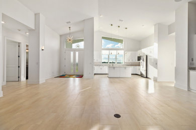 Open concept kitchen - large 1960s u-shaped porcelain tile open concept kitchen idea in Other with flat-panel cabinets, white cabinets, solid surface countertops and an island