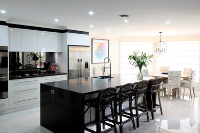 Small contemporary single-wall eat-in kitchen in Sydney with an undermount sink, mirror splashback, stainless steel appliances, porcelain floors and with island.