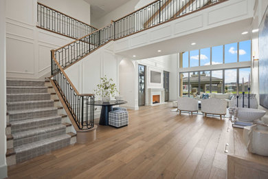 Foyer - large medium tone wood floor foyer idea in Other with white walls