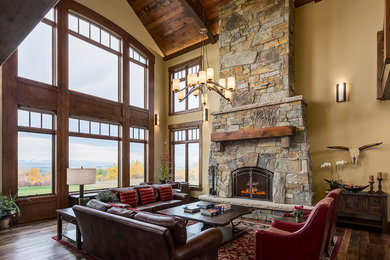 Living room - large rustic open concept medium tone wood floor and brown floor living room idea in Calgary with yellow walls, a standard fireplace, a stone fireplace and no tv