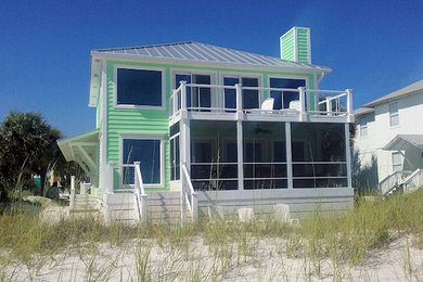 Mid-sized beach style green two-story vinyl exterior home photo in Other with a tile roof