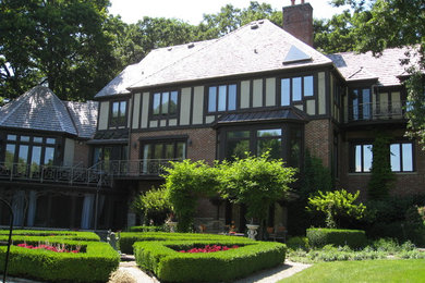 Mid-sized traditional three-story brick exterior home idea in Chicago with a hip roof