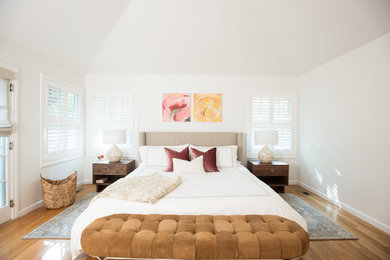 Inspiration for a transitional master bedroom in Other with white walls, medium hardwood floors and brown floor.