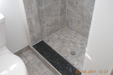 Small elegant gray tile and porcelain tile porcelain tile alcove shower photo in Portland Maine with a two-piece toilet and white walls