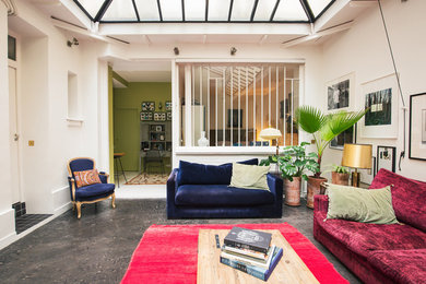 Inspiration pour un salon design ouvert et de taille moyenne avec sol en béton ciré, aucun téléviseur, un mur vert et un sol gris.
