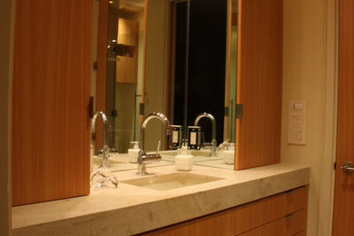 Double shower - contemporary 3/4 beige tile ceramic tile double shower idea in San Diego with flat-panel cabinets, brown cabinets, an undermount sink, marble countertops, a wall-mount toilet, beige walls and a hinged shower door