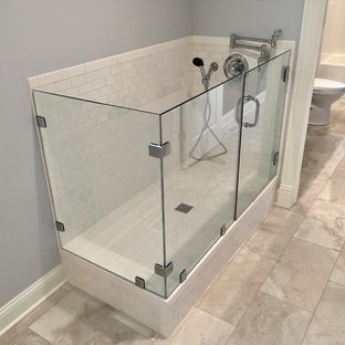 他の地域の大きいカントリー風おしゃれな家事室 (レイズドパネル扉のキャビネット、白いキャビネット、御影石カウンター、グレーの壁、磁器タイルの床、左右配置の洗濯機・乾燥機、マルチカラーの床、青いキッチンカウンター) の写真