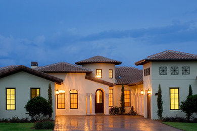 Inspiration for a mid-sized mediterranean one-storey stucco white exterior in Orlando with a hip roof.