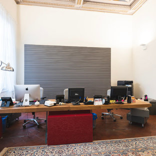 フィレンツェの大きいモダンスタイルのおしゃれな書斎 (白い壁、テラコッタタイルの床、自立型机、茶色い床) の写真