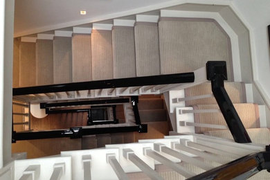 Photo of an expansive contemporary carpeted u-shaped staircase in London with carpet risers.