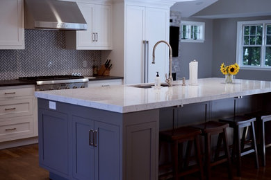 Inspiration for a country l-shaped dark wood floor and brown floor eat-in kitchen remodel in Boston with an undermount sink, shaker cabinets, gray cabinets, quartz countertops, white backsplash, ceramic backsplash, stainless steel appliances and an island