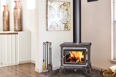 Living room - mid-sized traditional formal and enclosed medium tone wood floor living room idea in Other with white walls, a wood stove and no tv