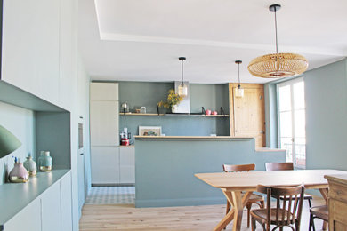 パリにある高級な広いコンテンポラリースタイルのおしゃれなキッチン (アンダーカウンターシンク、インセット扉のキャビネット、ベージュのキャビネット、人工大理石カウンター、青いキッチンパネル、パネルと同色の調理設備、セメントタイルの床、マルチカラーの床、茶色いキッチンカウンター、折り上げ天井) の写真