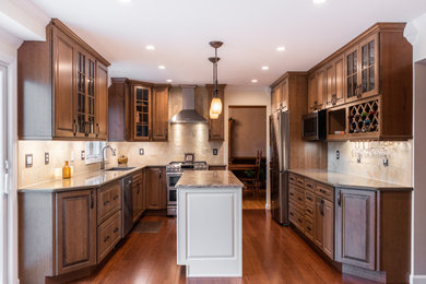 Eat-in kitchen - mid-sized traditional u-shaped medium tone wood floor and brown floor eat-in kitchen idea in Other with an undermount sink, raised-panel cabinets, dark wood cabinets, quartz countertops, beige backsplash, stone tile backsplash, stainless steel appliances, an island and multicolored countertops