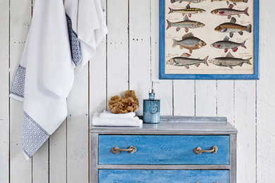 Photo of a beach style bathroom with white walls, terra-cotta floors and wood benchtops.