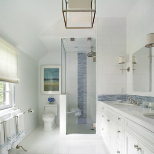 Cette image montre une grande douche en alcôve principale traditionnelle avec un lavabo encastré, un placard avec porte à panneau encastré, des portes de placard blanches, un WC séparé, un carrelage bleu, des carreaux en allumettes, un plan de toilette en marbre, un mur blanc, un sol en carrelage de céramique et un plan de toilette blanc.