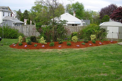 Photo of a large traditional drought-tolerant and full sun backyard mulch and wood fence lawn edging in Philadelphia.