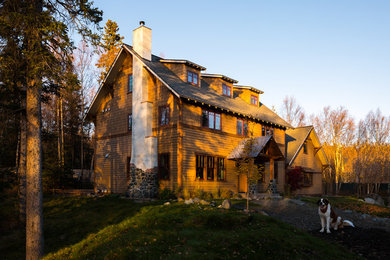 This is an example of a large arts and crafts two-storey brown exterior in Other with wood siding and a gable roof.
