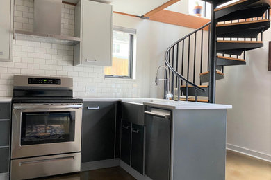 Inspiration for a small contemporary u-shaped concrete floor and beige floor open concept kitchen remodel in Portland with a farmhouse sink, flat-panel cabinets, gray cabinets, quartz countertops, white backsplash, subway tile backsplash, stainless steel appliances and white countertops