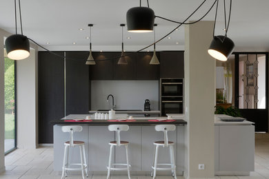 This is an example of a large contemporary single-wall open plan kitchen in Other with an integrated sink, beaded inset cabinets, dark wood cabinets, grey splashback, stainless steel appliances, with island, beige floor and grey benchtop.