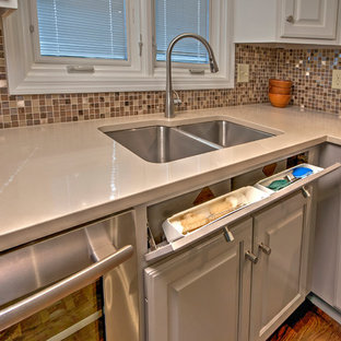 Inspiration pour une arrière-cuisine design en U de taille moyenne avec un évier encastré, un placard avec porte à panneau encastré, des portes de placard grises, un plan de travail en quartz, une crédence métallisée, une crédence en carreau de verre, un électroménager en acier inoxydable, un sol en bois brun et aucun îlot.