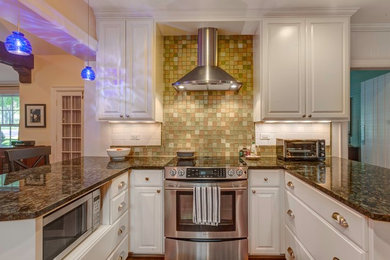 Example of a mid-sized transitional u-shaped medium tone wood floor open concept kitchen design in Nashville with an undermount sink, raised-panel cabinets, white cabinets, granite countertops, multicolored backsplash, glass tile backsplash, stainless steel appliances and a peninsula