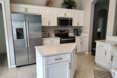Example of a mid-sized transitional eat-in kitchen design in Tampa with shaker cabinets, white cabinets and an island
