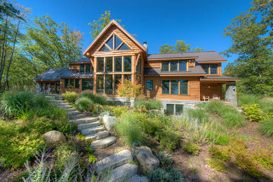 Large rustic brown two-story wood exterior home idea in Other with a metal roof
