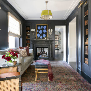 Inspiration for a large transitional home office in Chicago with a library, blue walls, dark hardwood floors, a standard fireplace, a plaster fireplace surround and brown floor.