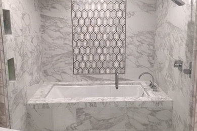 Inspiration for a mid-sized contemporary master gray tile, white tile and marble tile marble floor tub/shower combo remodel in Jackson with shaker cabinets, white cabinets, an undermount tub, white walls, an undermount sink and marble countertops