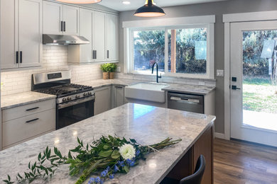 Design ideas for a mid-sized transitional kitchen in Albuquerque with white cabinets, with island and beige benchtop.