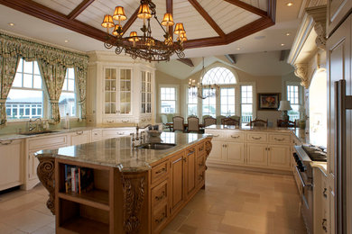 Photo of a large traditional u-shaped separate kitchen in New York with an undermount sink, raised-panel cabinets, white cabinets, granite benchtops, stainless steel appliances, travertine floors, with island and beige floor.