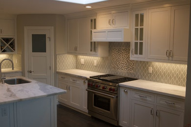 Inspiration for a huge modern l-shaped dark wood floor eat-in kitchen remodel in Orange County with a single-bowl sink, shaker cabinets, white cabinets, marble countertops, green backsplash, porcelain backsplash, stainless steel appliances and an island