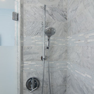 Traditional master bath utilizing frosted and clear glass to allow for needed pr