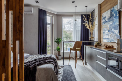Example of a small urban l-shaped laminate floor and beige floor open concept kitchen design in Other with an undermount sink, flat-panel cabinets, gray cabinets, wood countertops, gray backsplash, glass sheet backsplash, paneled appliances, no island and beige countertops