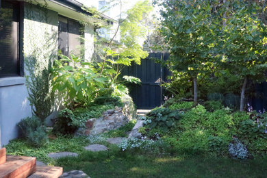 Inspiration for a mid-sized front yard partial sun garden in Melbourne with with privacy feature and a wood fence.