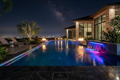 Pool fountain - large modern backyard tile and rectangular infinity pool fountain idea in Tampa